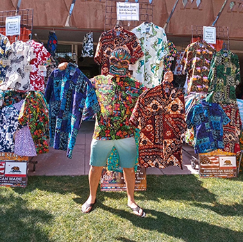 Man in Tiki mask showcasing Hawaiian shirts